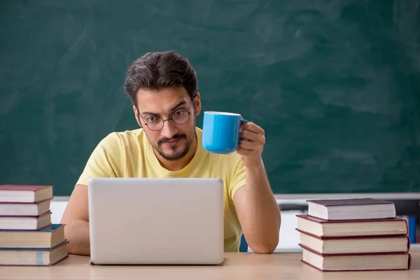 Jovem estudante se preparando para exames em sala de aula — Fotografia de Stock