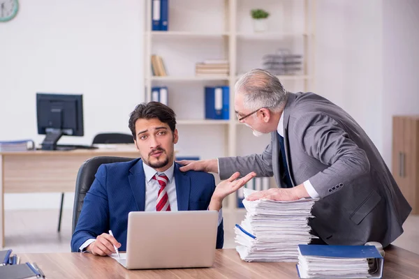 Zwei männliche Mitarbeiter arbeiten im Büro in Mobbing-Konzept — Stockfoto