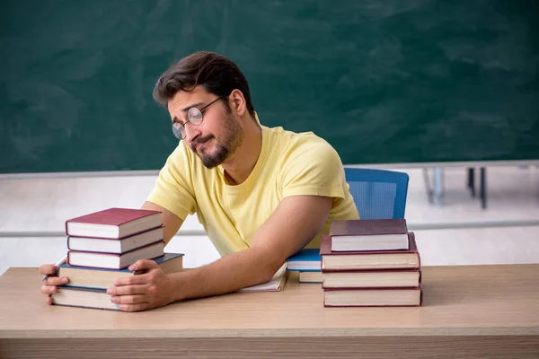 Jonge mannelijke student bereidt zich voor op examens in de klas — Stockfoto