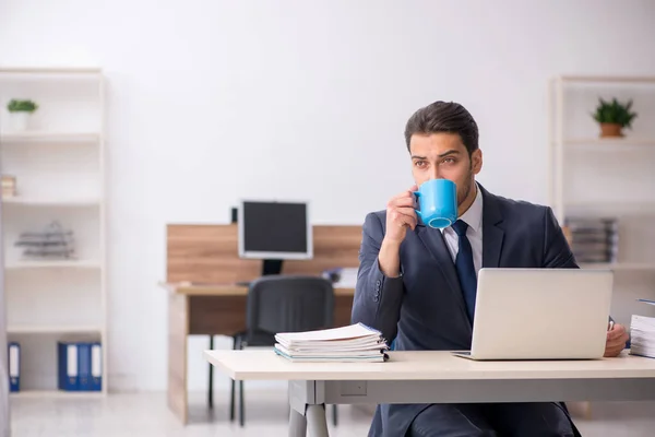 Jonge mannelijke werknemer die koffie drinkt tijdens de pauze — Stockfoto