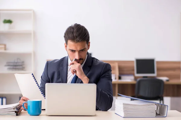 Empleado joven sentado en el lugar de trabajo — Foto de Stock