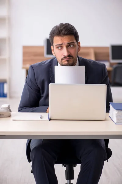 Jeune employé masculin assis sur le lieu de travail — Photo