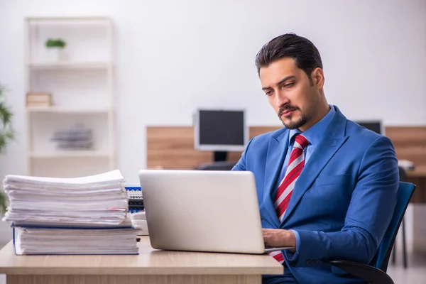 Joven empleado descontento con el trabajo excesivo en el lugar de trabajo —  Fotos de Stock