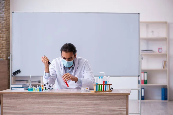 교실에 앉아 있는 젊은 남성 화학자 — 스톡 사진