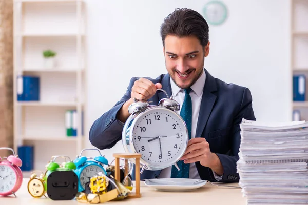 Jovem empresário empregado comer despertador-relógio — Fotografia de Stock