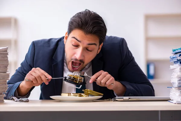 Молодой бизнесмен ест будильник — стоковое фото