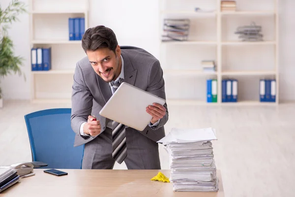 Junge männliche Angestellte unzufrieden mit exzessiver Arbeit im Büro — Stockfoto