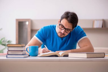 Evde okuyan genç bir erkek öğrenci.