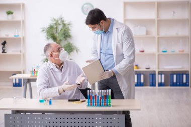 Salgın sırasında laboratuvarda çalışan iki erkek kimyager.