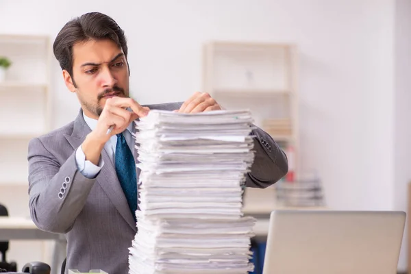 Joven empleado masculino descontento con el trabajo excesivo en la oficina —  Fotos de Stock