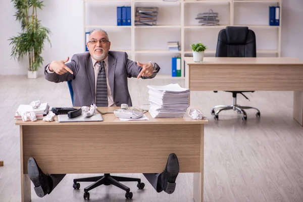 Oude mannelijke werknemer die op de werkplek werkt — Stockfoto