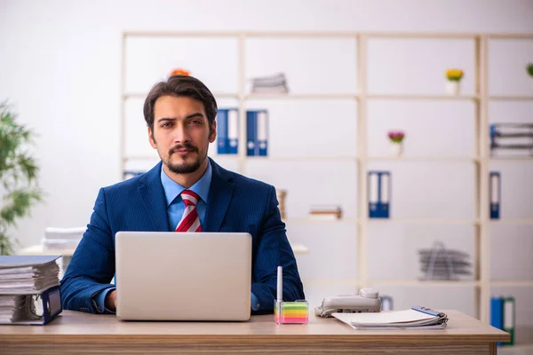 Jeune employé masculin assis sur le lieu de travail — Photo