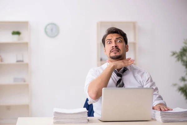 Jovem funcionário masculino infeliz com excesso de trabalho no escritório — Fotografia de Stock