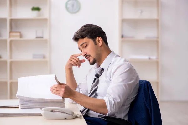 Ung manlig anställd missnöjd med överdrivet arbete på kontoret — Stockfoto