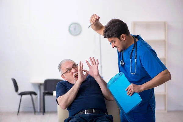 Yaşlı adam genç erkek doktoru ziyaret ediyor. — Stok fotoğraf