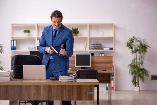 Junge männliche Angestellte mit Waffe am Arbeitsplatz — Stockfoto