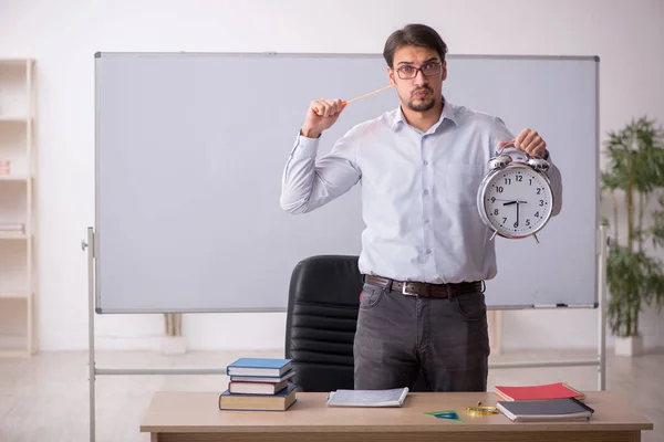 Jonge mannelijke leraar in time management concept — Stockfoto