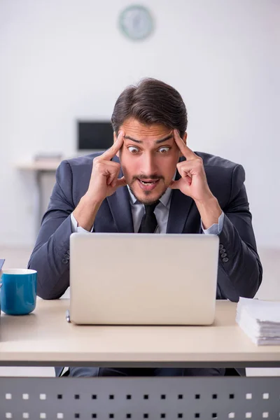 Jovem trabalhador masculino sentado no local de trabalho — Fotografia de Stock