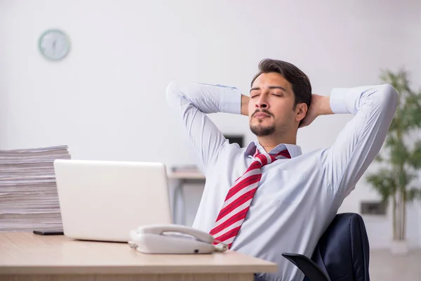 Jovem trabalhador masculino sentado no local de trabalho — Fotografia de Stock