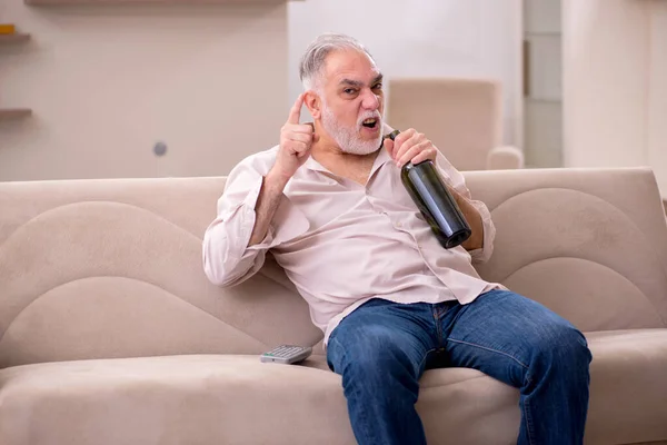 Vieil homme buvant de l'alcool à la maison — Photo