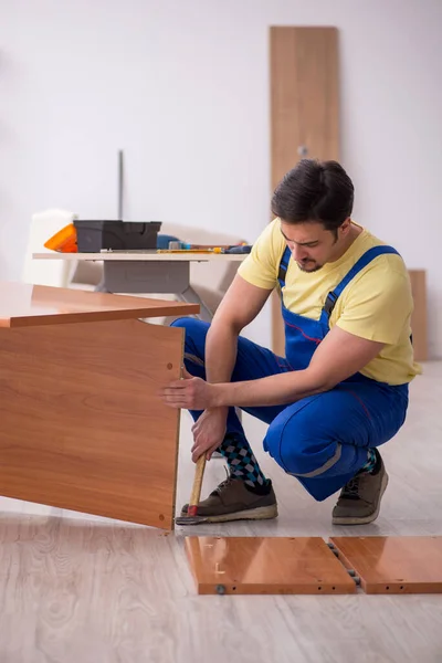 Genç erkek marangoz ofiste masa onarıyor. — Stok fotoğraf