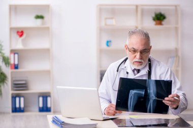 Klinikte çalışan yaşlı bir erkek radyolog.