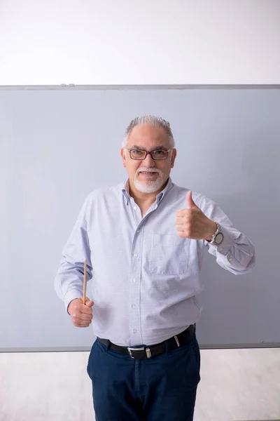 Velho professor masculino na frente do quadro branco — Fotografia de Stock