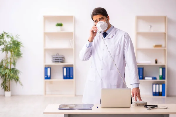 Jovem médico do sexo masculino no conceito de telemedicina durante a pandemia — Fotografia de Stock