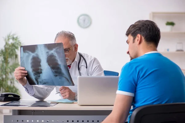 Jonge mannelijke patiënt op bezoek bij oude mannelijke arts radioloog — Stockfoto