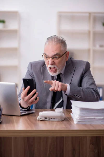 Old male employee working in the office — Stock Photo, Image