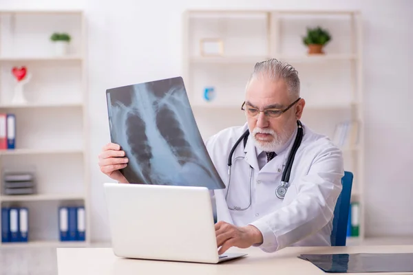 Gammal manlig röntgenläkare som arbetar på kliniken — Stockfoto