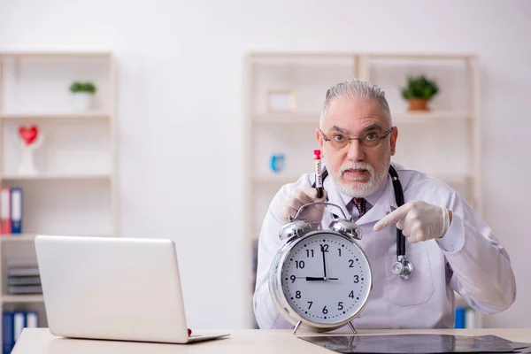 Old male doctor in time management concept — Stock Photo, Image