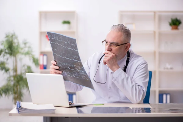 Gammal manlig röntgenläkare som arbetar på kliniken — Stockfoto