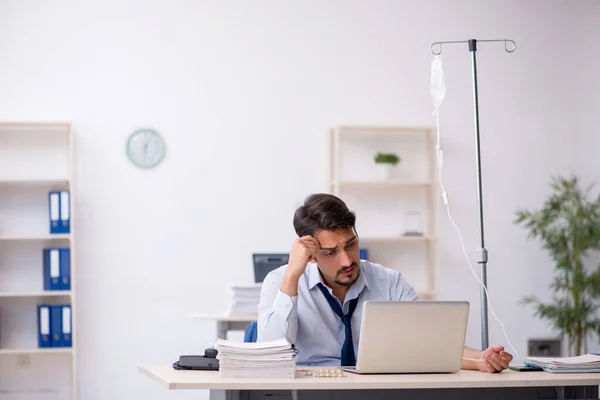 Junge männliche Mitarbeiter leiden am Arbeitsplatz — Stockfoto