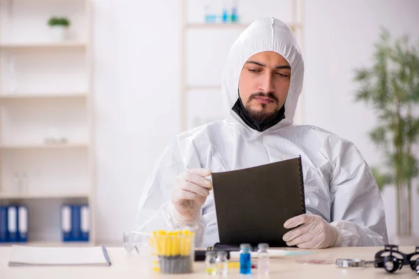 Młody chemik pracujący w laboratorium podczas pandemii — Zdjęcie stockowe