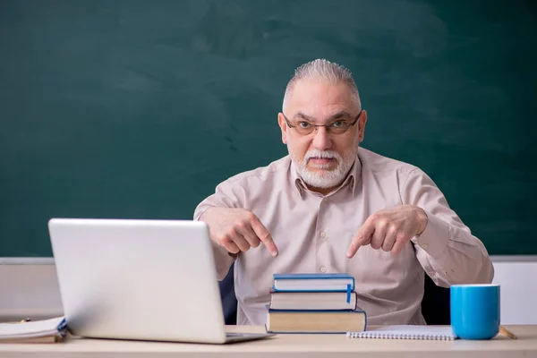 Oude mannelijke leraar voor schoolbord — Stockfoto