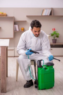 Young male contractor disinfecting at home