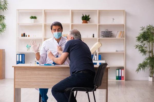 Vieil homme visitant jeune médecin dans le concept de vaccination covid-19 — Photo