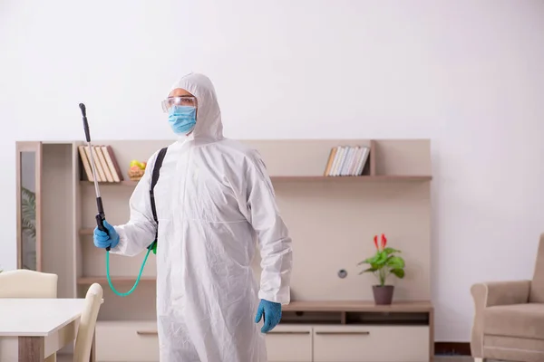 Young male contractor disinfecting at home — Stockfoto