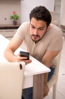 Genç adam ve evde bir sürü hamamböceği var.