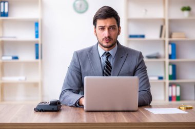 Genç yakışıklı işadamı ofiste çalışıyor.