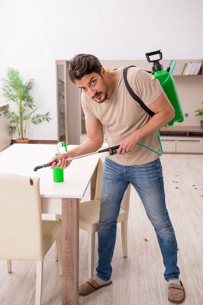 Young man exterminating cockroaches at home — Stock Photo, Image