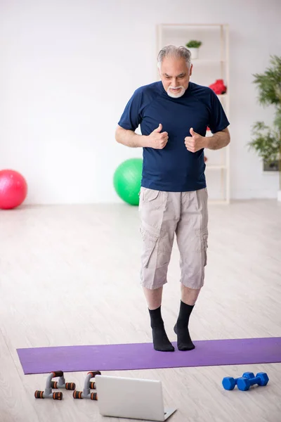 Old man doing sport exercises indoors — Stock Photo, Image