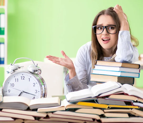 Ung kvinnlig student förbereder sig för tentor med många böcker i tid — Stockfoto