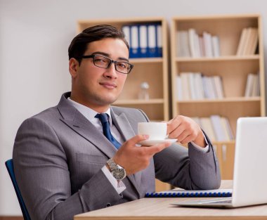 Genç yakışıklı işadamı ofiste çalışıyor.