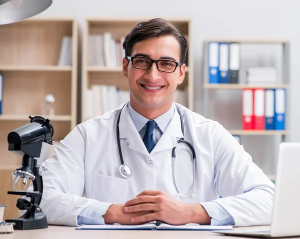 Médico adulto joven con computadora portátil —  Fotos de Stock