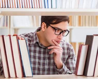 Üniversite kütüphanesinde kitap arayan genç bir öğrenci.