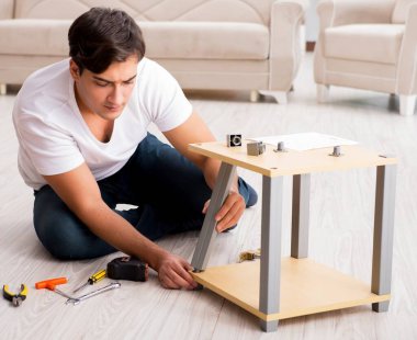 Evdeki rafları monte eden adam