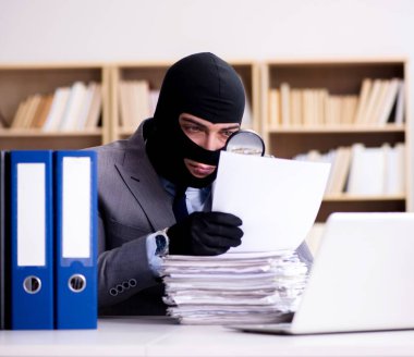 Suçlu iş adamı ofiste kar maskesi giyiyor.