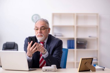 Ofiste çalışan yaşlı bir erkek.